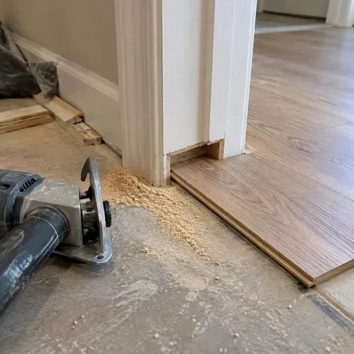 Door jamb undercut beside engineered plank during engineered hardwood installation