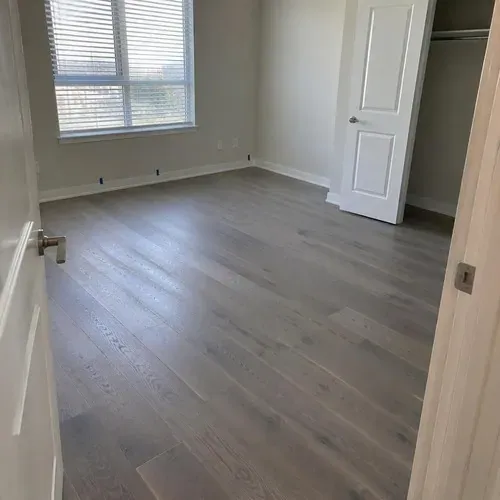 Finished gray-washed engineered floor in condo bedroom after engineered hardwood installation