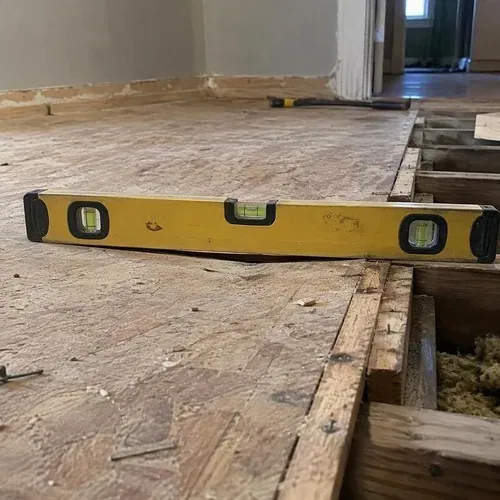Level showing gap on sagging floor before floor and subfloor repair