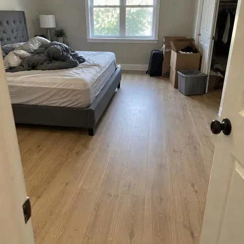 Finished light oak laminate in bedroom after vinyl and laminate flooring installation